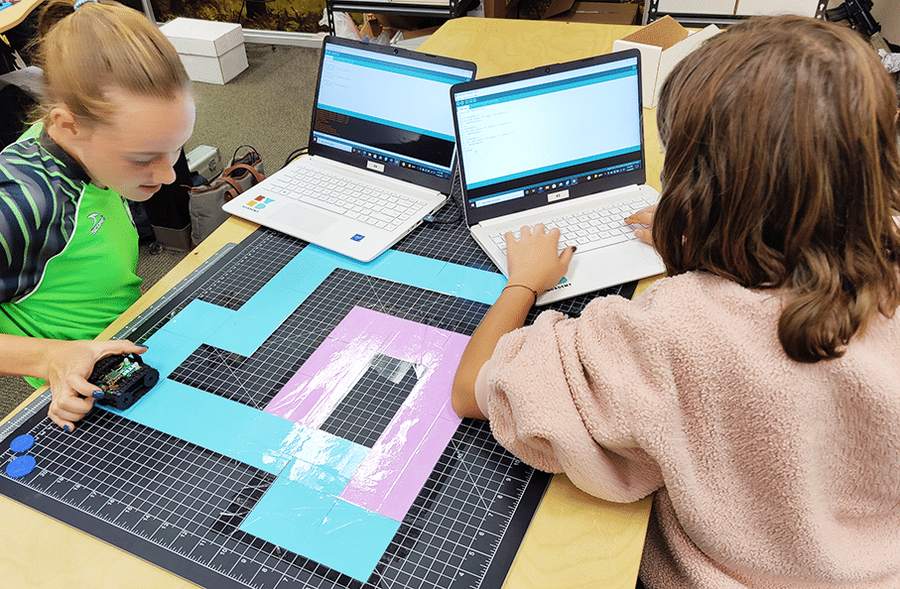 Students coding a small robot after school
